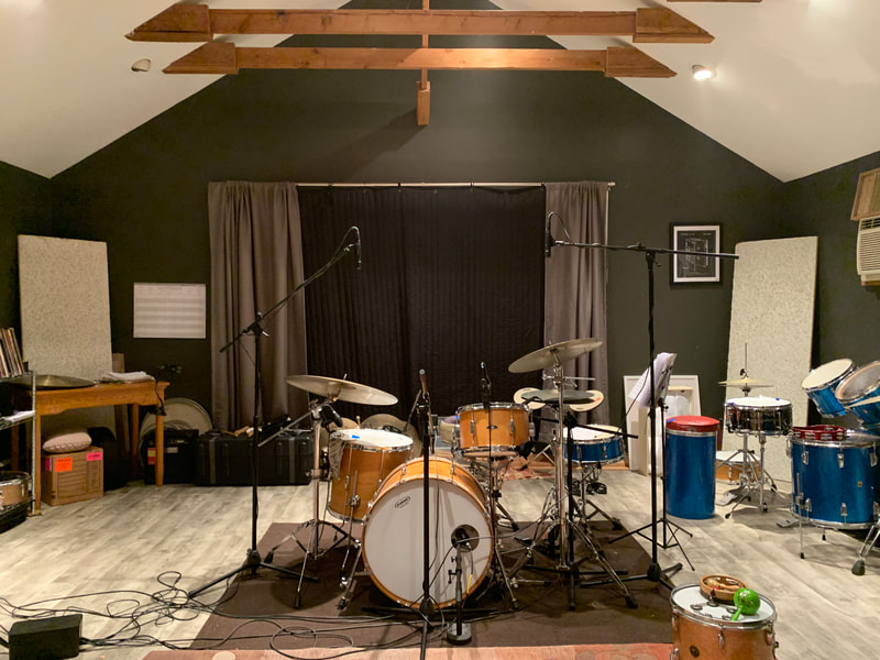 Josh's drum studio featuring a large drum kit in the center of the frame.
